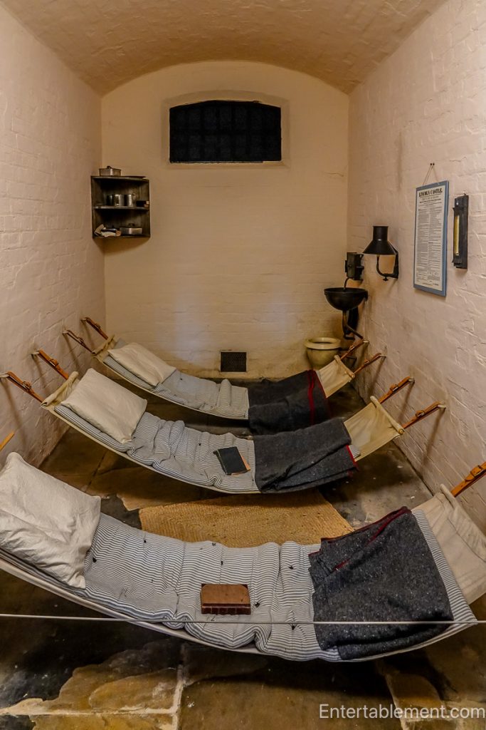 Refitted Victorian prison cell in Lincoln Castle, showing overcrowded conditions with canvas hammocks.