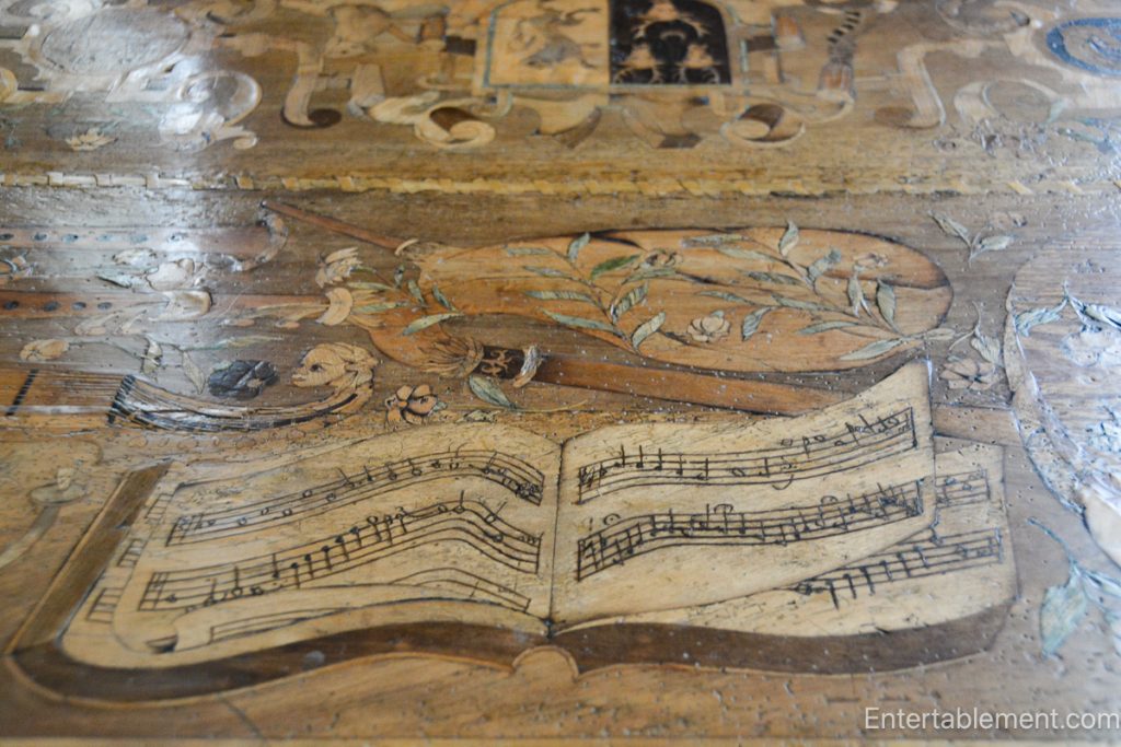 The Eglantine Table at Hardwick Hall, showcasing intricate inlaid designs of musical instruments and playing cards.