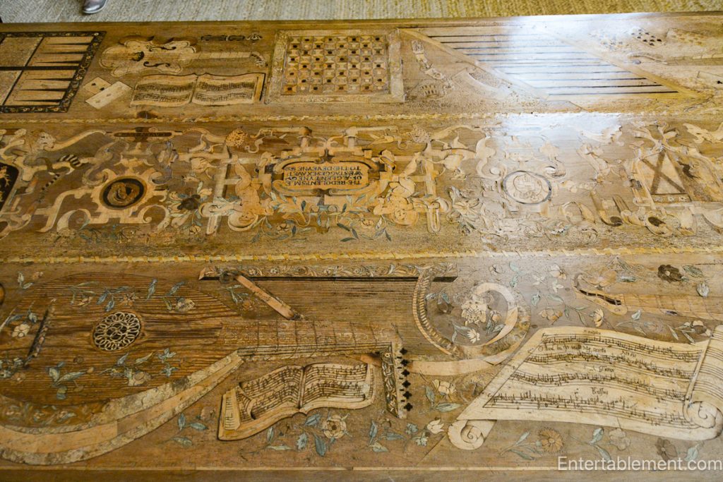 The Eglantine Table at Hardwick Hall, showcasing intricate inlaid designs of musical instruments and playing cards.