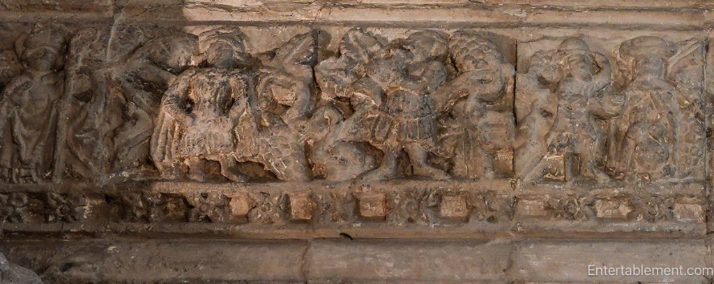 Medieval stone lintel depicting symbolic figures representing sin and mortality
