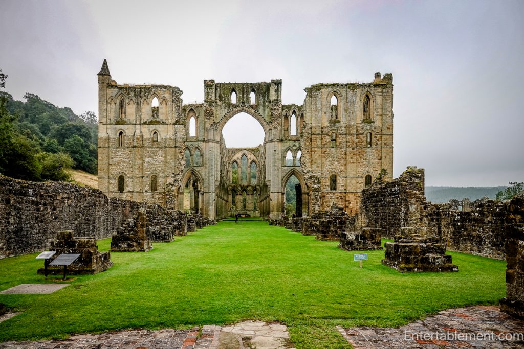 West front of Rievaulx Abbey showing the remains of twin towers and the large central arch opening into the nave.