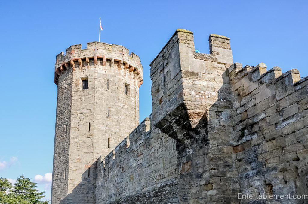 Stone towers and curtain walls of Warwick Castle, a major stronghold during the Wars of the Roses.