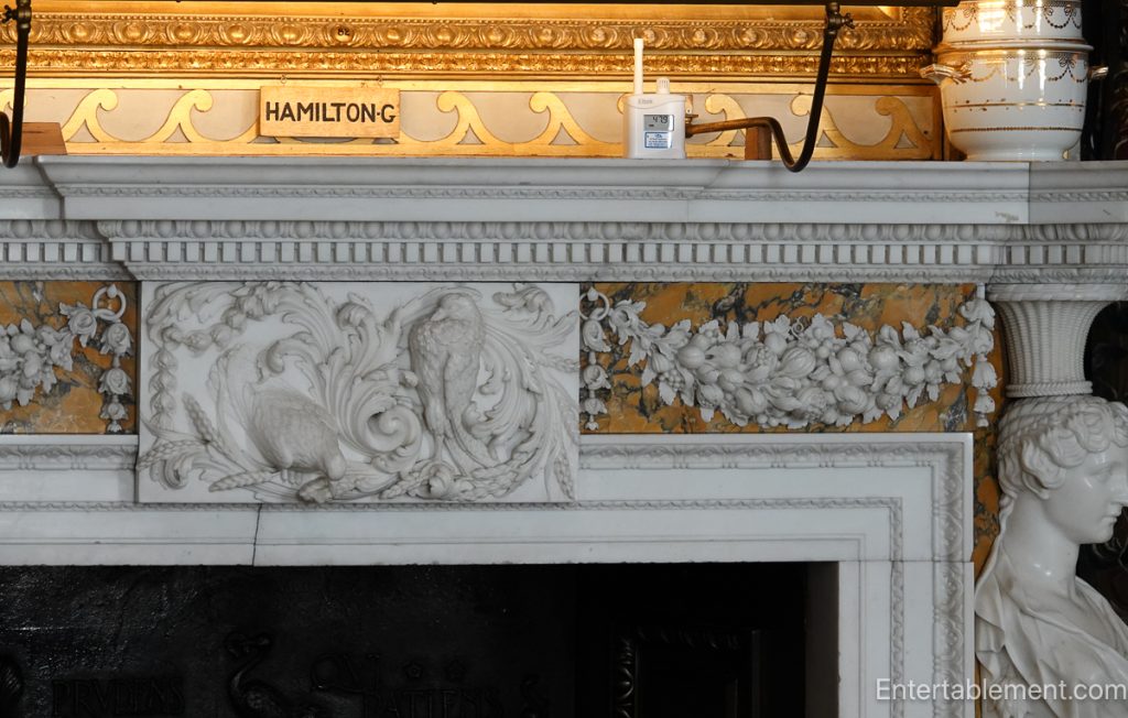 Carved marble fireplace at Holkham Hall with classical figures and decorative garlands
