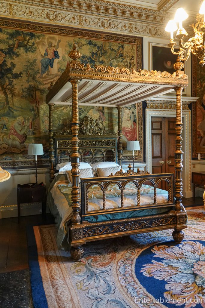 State bedroom at Holkham Hall with canopy bed, tapestries on walls and gilded architectural detailing