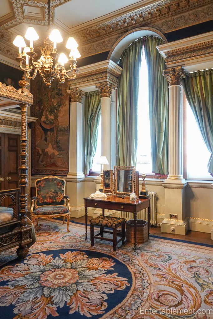 State bedroom at Holkham Hall with canopy bed, tapestries on walls and gilded architectural detailing