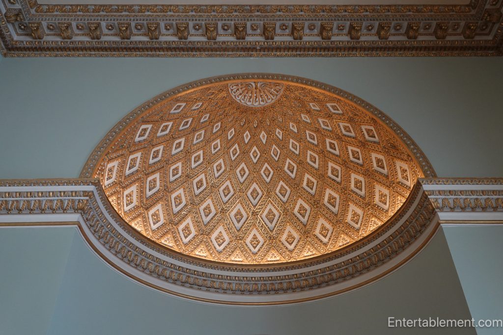 Domed ceiling of the Saloon at Holkham Hall with geometric coffering and filtered natural light