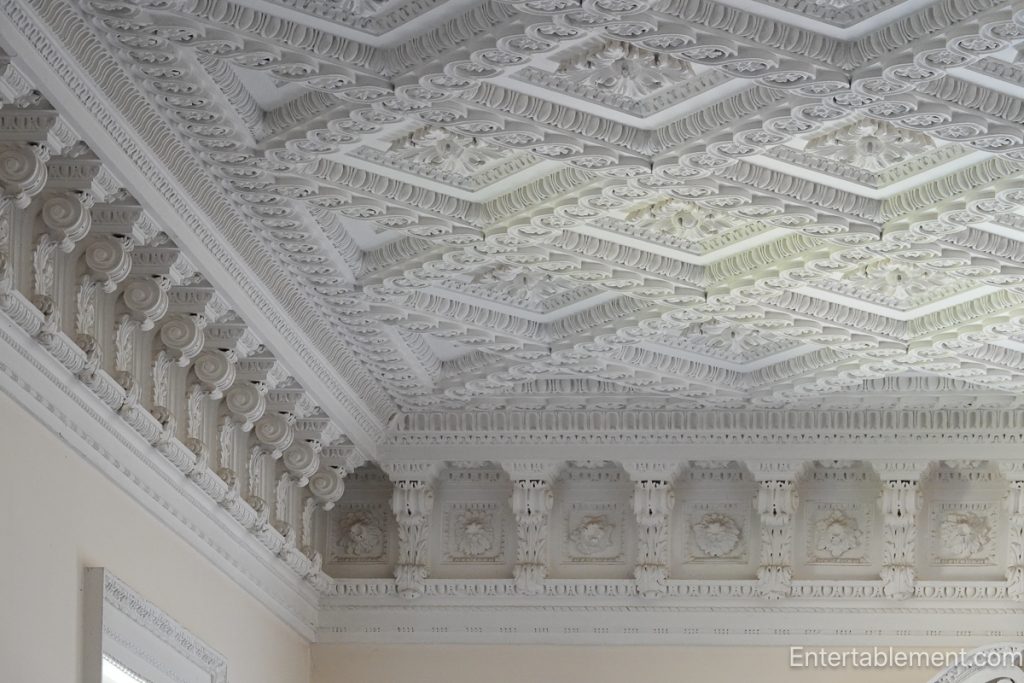 Elaborate white plaster coffered ceiling with classical motifs and deep relief detail