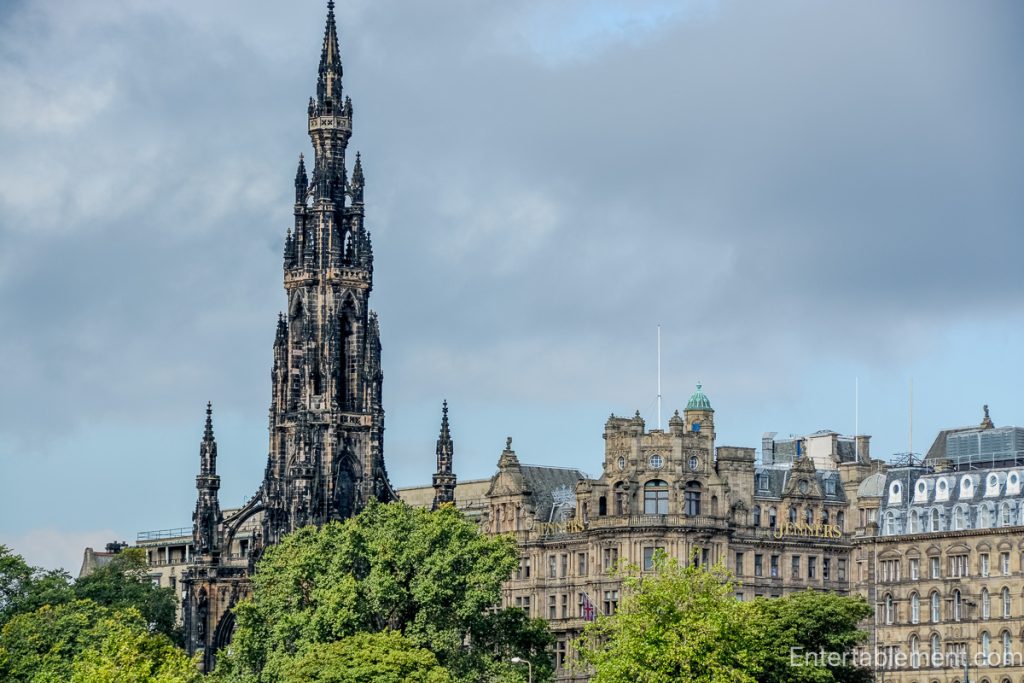 Gothic spire of the Scott Monument rising above trees and ornate buildings on Princes Street, Edinburgh