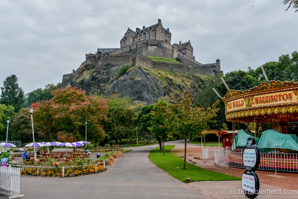 Edinburgh Castle overlooking a colourful carousel and garden paths in Princes Street Gardens