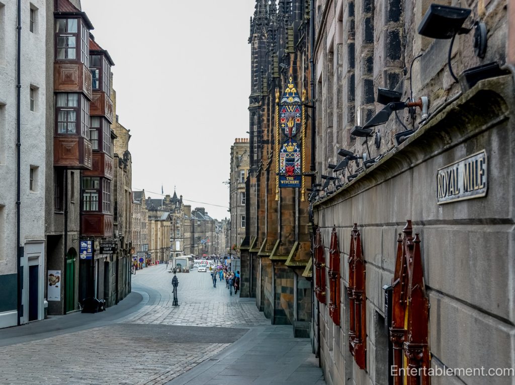 Cobblestone street along Edinburgh’s Royal Mile, lined with historic stone buildings and projecting bay windows